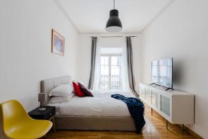 a bedroom with a bed and a yellow chair at Elegant Apartment Via Veneto by Varental in Rome