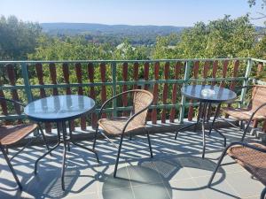 un patio con mesas y sillas en el balcón en Attila-Apartman Budaörs, en Budaörs