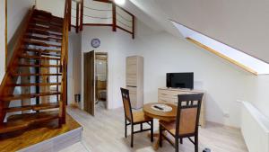 uma sala de jantar com uma mesa e cadeiras e uma escadaria em Na starém městě Volary em Volary