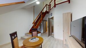 a room with a wooden table and a staircase at Na starém městě Volary in Volary