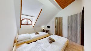 two beds in a room with white walls at Na starém městě Volary in Volary