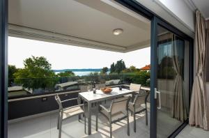 a patio with a table and chairs on a balcony at Villa Marija in Sveti Filip i Jakov