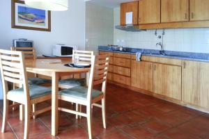 eine Küche mit einem Tisch und Stühlen in einer Küche in der Unterkunft Chalet in Lagoa with Natural Pools Nearby in Rosário-Lagoa