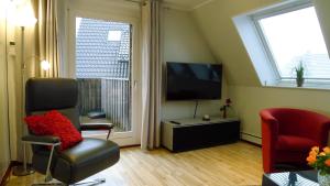 - un salon avec une télévision à écran plat et deux chaises dans l'établissement Ferienwohnung Schuberski, à Lipperreihe