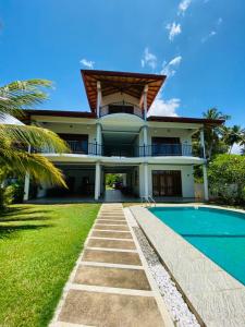 a house with a swimming pool in front of it at Villa Riverside in Aluthgama