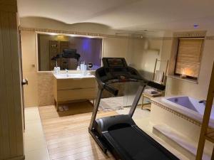 a room with a treadmill and a bathroom with a tub at holiday home, Swinoujscie in Świnoujście