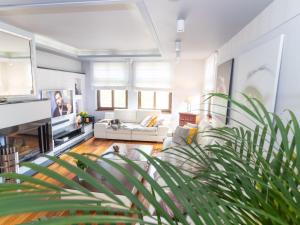 a living room with white furniture and a plant at holiday home, Swinoujscie in Świnoujście