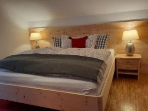 ein Schlafzimmer mit einem großen Bett mit zwei Lampen an Tischen in der Unterkunft Biohof Schmiedbauer in Sankt Martin