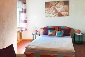 a bedroom with a bed and a painting on the wall at Holiday home Seeblick, Schoenberg in Schönberg