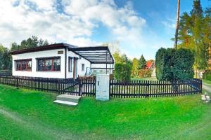 a small house with a fence in the grass at Holiday home Seeblick, Schoenberg in Schönberg