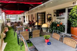 un patio al aire libre con mesas, sillas y plantas en Hotel Gambrinus Arnsberg, en Arnsberg