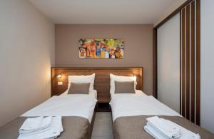 two beds in a hotel room next to each other at Villa Marija in Sveti Filip i Jakov +147 photos