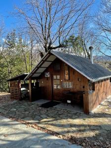 Cabaña de madera pequeña con techo negro en Villa Lochia - Η καλύβα του Τρύφωνα, en Rámia