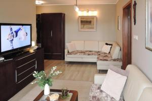 a living room with a white couch and a tv at Holiday flat, Swinoujscie in Świnoujście