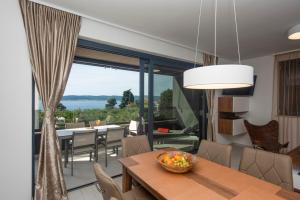 a dining room with a table and a view of the ocean at Villa Ivan in Sveti Filip i Jakov