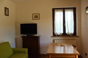 ペトリニャーノにあるDa Ginetto Assisiのリビングルーム(ソファ、テレビ、テーブル付)