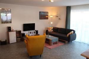 ein Wohnzimmer mit einem Sofa und einem TV in der Unterkunft Ferienwohnung Andergasse in Neustadt an der Weinstraße