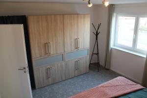 Ferienwohnung Andergasse في نويشتات أن در فاينشتراسه: غرفة نوم مع خزانة خشبية كبيرة مع ثلاثية