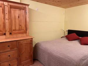 1 dormitorio con 1 cama y armario de madera en Appartement for Holiday Lodge 1891 en Stalden
