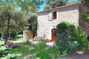 a stone house with a red door in a yard at holiday home, Grignan in Gourdon