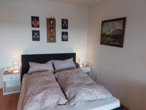 ein Bett in einem Schlafzimmer mit Bildern an der Wand in der Unterkunft Apartment 365 mit Sauna, Schwimmbad und Fitness in Schönwald