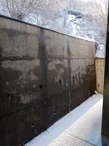 un mur en béton avec de la neige sur son côté dans l'établissement Appartement Super Besse, à Super-Besse