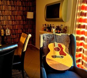a guitar sitting on a chair in a room at Bakarloko Lipno Apartments in Lipno nad Vltavou