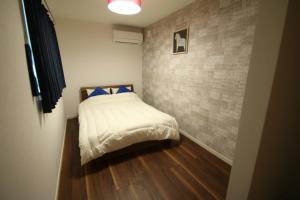niewielka sypialnia z łóżkiem z niebieskimi poduszkami w obiekcie Kumamoto - House - Vacation STAY 89433 w mieście Kumamoto