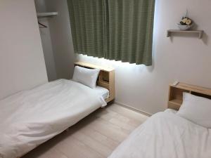 a small room with two beds and a window at Kumamoto - House / Vacation STAY 75194 in Kumamoto
