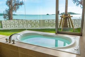 恩納的住宿－Villa VALIOSA ON THE BEACH，享有水景的浴缸