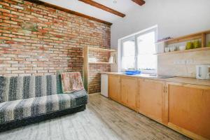 a kitchen with a brick wall and a couch in a room at 2 room holiday apartment for 3 people Rusinowo in Rusinowo