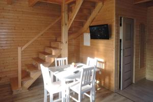 una sala da pranzo con tavolo e sedie bianchi di Terraced House in Rewal near Baltic Beach a Rewal Altre 16 foto