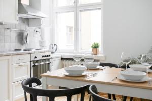 - une cuisine avec une table en bois et des verres à vin dans l'établissement 2ndhomes Central & Spacious 85m2 apartment in Yrjönkatu, à Helsinki