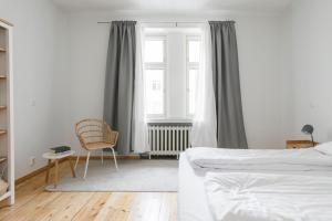 - une chambre avec un lit, une chaise et une fenêtre dans l'établissement 2ndhomes Central & Spacious 85m2 apartment in Yrjönkatu, à Helsinki