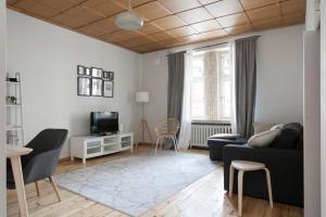 - un salon avec un canapé et une télévision dans l'établissement 2ndhomes Central & Spacious 85m2 apartment in Yrjönkatu, à Helsinki