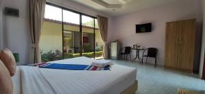 um quarto com uma cama e uma mesa com cadeiras em Phuket Sirinapha Resort em Praia de Nai Yang