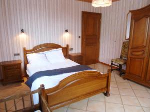 ein Schlafzimmer mit einem großen Holzbett und einem Stuhl in der Unterkunft Appartement de 3 chambres avec wifi a Epfig in Epfig