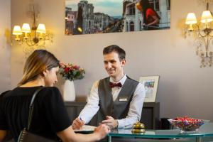 a man and a woman sitting at a table in a restaurant at Best Western Hotel Lakmi Nice in Nice
