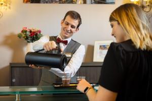 a man in a bow tie and a woman with a camera at Best Western Hotel Lakmi Nice in Nice
