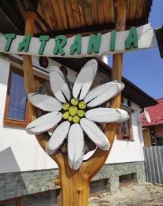 a sign for a farm with a flower on it at Hotel Tatrania in Stará Lesná