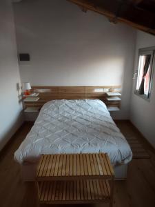 CorteZecchina في بيوفي دي ساكّو: غرفة نوم بسرير ومقعد خشبي