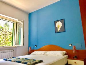 ein blaues Schlafzimmer mit einem Bett und einem Fenster in der Unterkunft Villa I Gemelli in Vieste