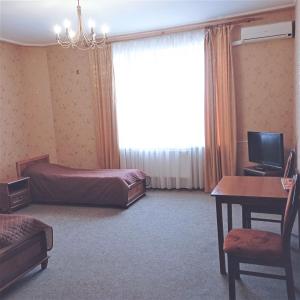 a hotel room with a bed and a desk and a window at У КоТа in Vinnytsya