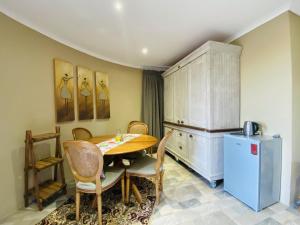 a kitchen with a table and chairs and a refrigerator at Country Lane Farm lodge in Cradock