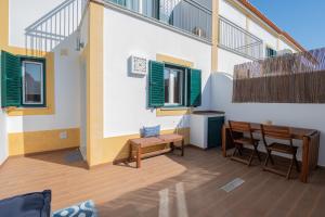 a patio with a table and chairs and windows at MilDreams House in Vila Nova de Milfontes +12 photos