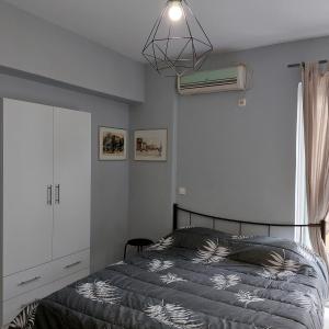 Schlafzimmer mit einem Bett, einem Ventilator und einem Fenster in der Unterkunft Yolanda Studios in Piräus