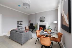 a living room with a couch and a table at JOIVY Luxurious 2 BR apt on notable George Street in Edinburgh