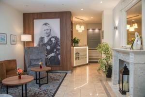 a lobby with two tables and a picture of a woman at Hotel Villa am Kurpark in Bad Homburg vor der Höhe