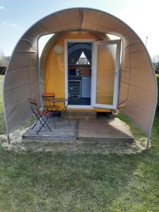 a dome tent with two chairs and a kitchen in it at Aux Cygnes D'Opale in Blangy-sur-Bresle