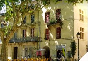 ein Gebäude mit Tischen und Stühlen davor in der Unterkunft Appartement accueillant à Beaucaire - 90 m², idéal pour les familles in Beaucaire